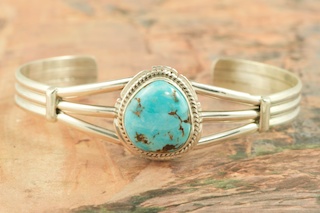 Genuine Castle Dome Turquoise set in Sterling Silver Bracelet. The Castle Dome Turquoise Mine is located about 30 miles from the Sleeping Beauty Mine, near Globe, Arizona. The Castle Dome Mine has not been in operation since the early 1970s. Created by Navajo Artist Milton Lee. Signed by the artist.